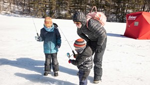 Sam Coleman helps his sons, George, 3, and Charlie, 8, ice fish with a jigging rod.