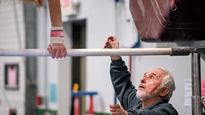 Coach Stefan Hruska working with a gymnast at the Green Mountain Training Center in Williston