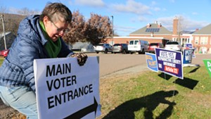 Liz Schlegel Stevens adjusting signs at a polling place in Waterbury Tuesday