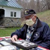 James J. Hasson, 94, flipping through World War II photos at his Cavendish home