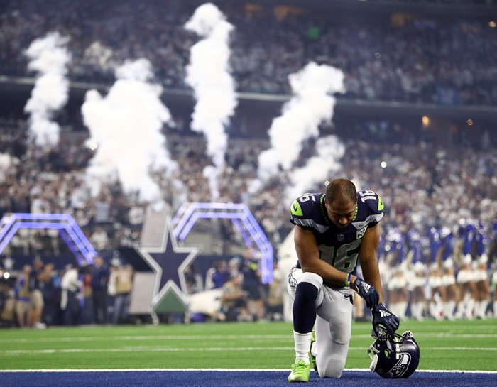 Tyler Lockett of the Seattle Seahawks kneels in the end zone before the game against the Dallas Cowboys during the Wild Card Round at AT&T Stadium.