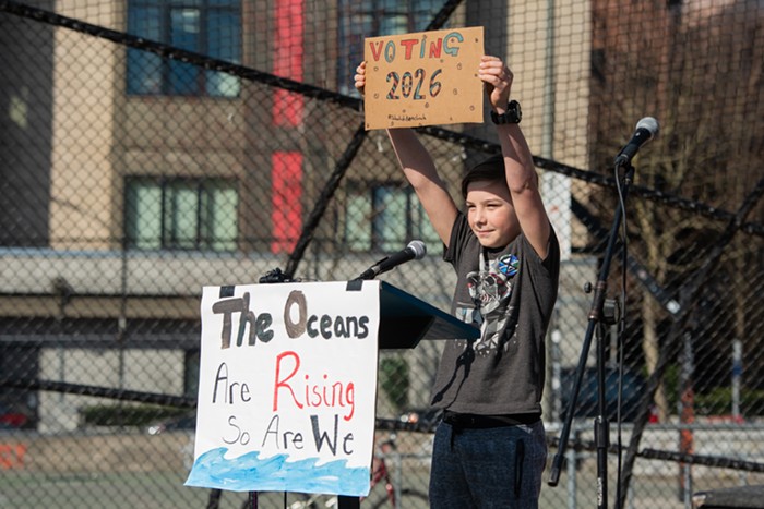 Taro, a 12-year-old student at Kenmore Middle School, holds up a sign signifying the first year hell be eligible to vote. Were standing on the only rock for billions of miles that can support life and were ruining it.