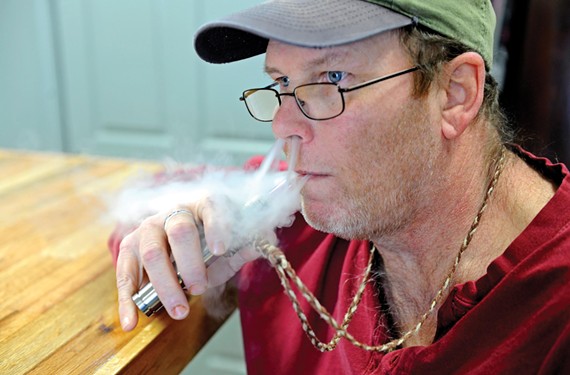 RVA Vapes customer David Payne, once a smoker of Swisher Sweets, puffs on a pineapple-upside-down-cake-flavored e-cig. - SCOTT ELMQUIST