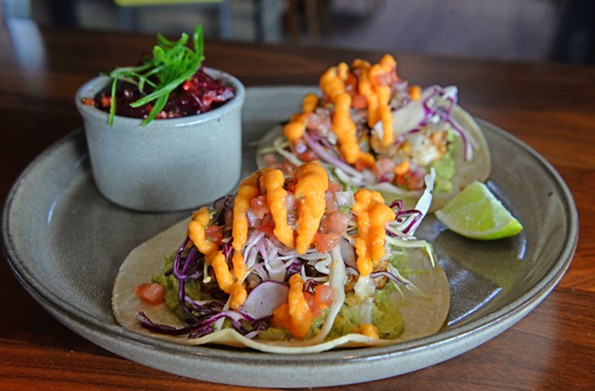 The grilled Gulf shrimp tacos feature a house dry rub, guacamole, cured cabbage, pico de gallo and papaya hot sauce served on two corn tortillas. - SCOTT ELMQUIST