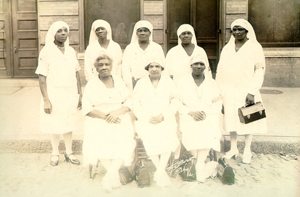 After learning that black patients suffering from the 1918 flu were being treated in the segregated basement of an emergency hospital, Maggie L. Walker, a banker and civic leader, successfully lobbied Governor Westmoreland Davis to convert the Baker School for the care of black patients. This facility was staffed by black doctors and nurses — such as these women photographed a few years after the flu pandemic in front of St. Luke Hall, headquarters of the Independent Order of St. Luke, the fraternal organization Walker led. - COURTESY OF THE MAGGIE L. WALKER NATIONAL HISTORIC SITE