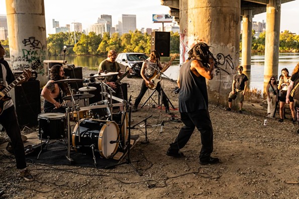 BlackLiq rocks the mic with Armagideon Time by the river. The cover for the group's EP "Crime as Theatre" appears to reference the 'Ku Klux Klown' effigies hung in Richmond's Bryan Park by the artist collective, Indecline, back in 2017. - RANDY BLYTHE