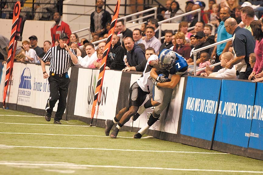 Wide receiver Rodney Landers is stopped after a catch by a defensive back from the Trenton Steel on opening night, March 19. There are no sidelines in arena football, just walls. - SCOTT ELMQUIST