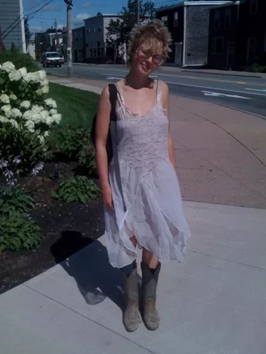 Kaleigh has got a lot going on here, cowboy boots on a hot sunny day, interesting glasses, fun hair, a facial piercing. The centrepiece, however, is the two slips she's wearing together as a dress. “I've worn it a lot this summer. All over Canada. But it originated at the Salvation Army on Green Street.” One of the slips is from a friend's mom. Taking a look at it, she realized it's all backwards, “but I'm hung over.” She popped out the frames of her sunglasses to put in prescription lenses. They are a throwback, huge, clear lenses with nice curvy gold coloured arms. The first ones she had put in were rose-coloured, “but I looked like a pink-eyed rat."