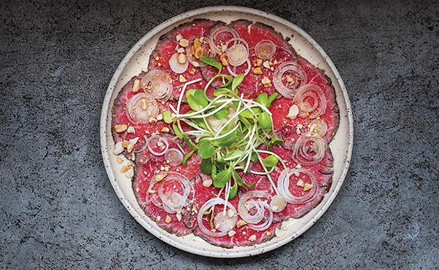 Beef tenderloin carpaccio with oishi, vinegar and chillies, sunflower shoots, peanuts and onion - JESSICA EMIN