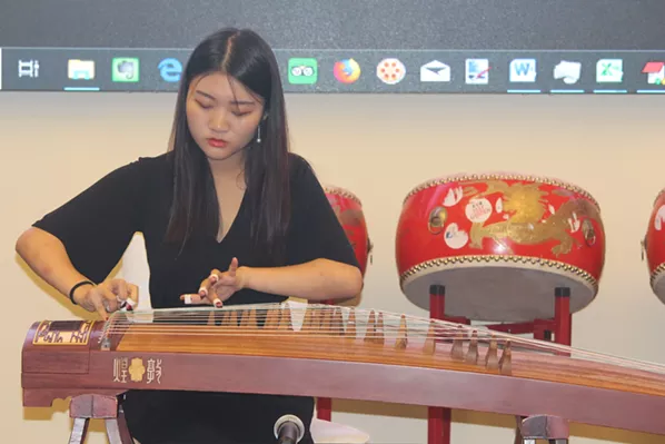 Linshan Sui performs a traditional Chinese instrumental solo, "The Spring in Lhasa," on her guzheng, known in English as a zither, at the August 22 press conference. - JAMES LATTER