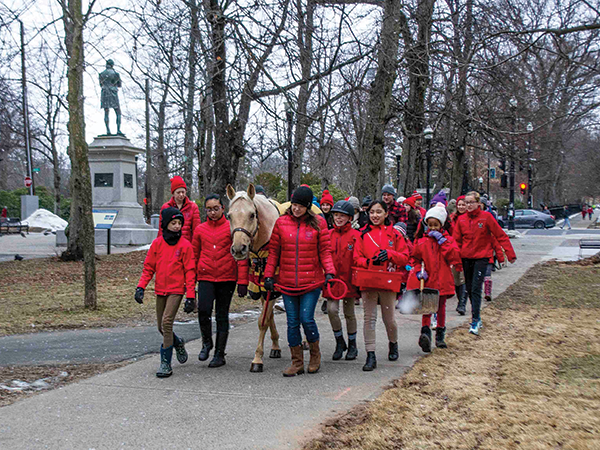 Angie Holt with a gaggle of Lancers walking Ben the pony to Ronald McDonald House. - SUBMITTED