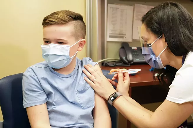 Nurse Laura Bailey injects eight-year-old Jack Woodhead with anti-COVID vaccine. - COMMUNICATIONS NOVA SCOTIA
