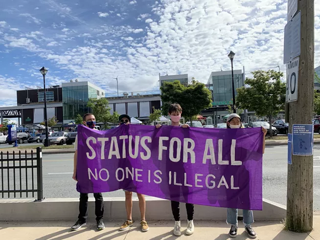 NOII volunteers outside the Seaport Farmers’ Market in August, 2020 making their call for full and permanent immigration status for all migrants. - SUBMITTED