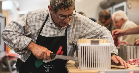 It takes a village (and a really sharp knife) to make 4,000 skewers of lamb rosticcini happen. - RILEY SMITH