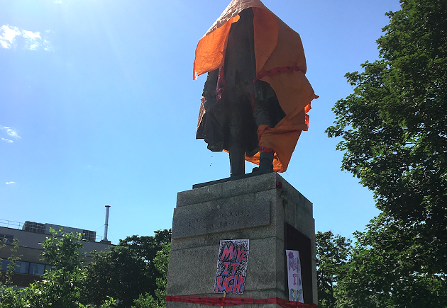Moments after city workers removed the black tarp, protesters re-covered the statue with a plastic sheet. - KAILA JEFFERD-MOORE