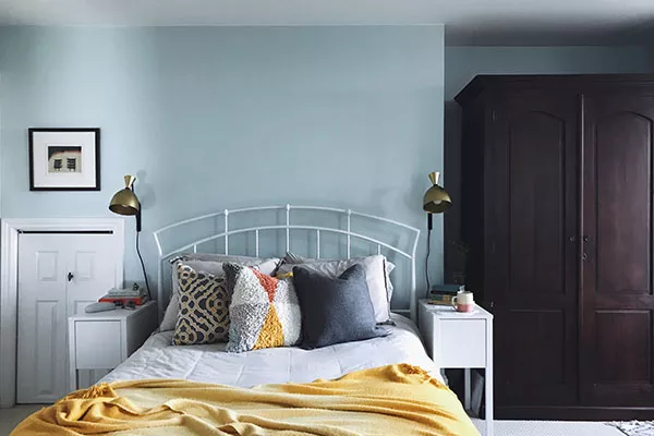 “We wanted something more minimalist in the bedroom that would have less of a footprint, a way to save space, so we put sconce lighting on the wall so the bedside table can be smaller but still pile your crap—adorably pile your crap.”