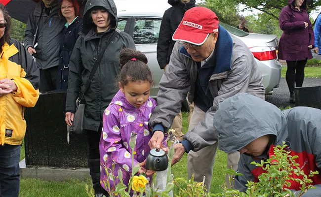George Lee Sr. pours some hot tea over his wife's grave. - JENNIFER LEE