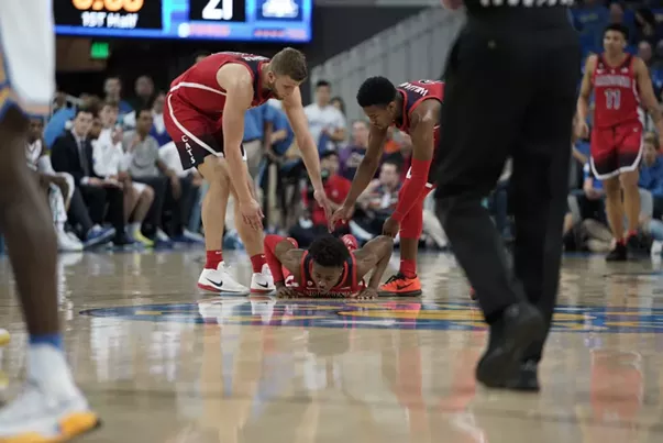 Arizona freshman Devonaire Doutrive gets some help up from his teammates during Arizona's 90-69 loss to UCLA on Saturday night. - CONNOR BUSS, FOREWORD FILMS