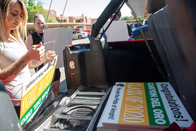 Canyon del Oro High School science teacher Jordan Castle prepares a yard sign for a CDO senior. - LOGAN BURTCH-BUUS / TUCSON LOCAL MEDIA