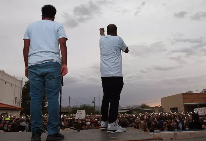 Event organizers Jahmar Anthony and Zion Givens ask the crowd to hold up a fist and observe an 8 minute and 46 second moment of silence for Geroge Floyd during the vigil at the Dunbar Pavilion on June 1, 2020. Floyd was killed Monday, May 25 after a police officer held his knee to the 46-year-old Minneapolis resident's neck for nearly nine minutes. - AUSTIN COUNTS