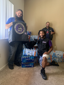Jaylon Sesay—a.k.a. Prospect Jay—with the Sho Ryders Tucson Chapter president and vice president pose with the plethora of water bottles they plan to distribute across Tucson this weekend. - SHO RYDERS MOTORCYCLE CLUB