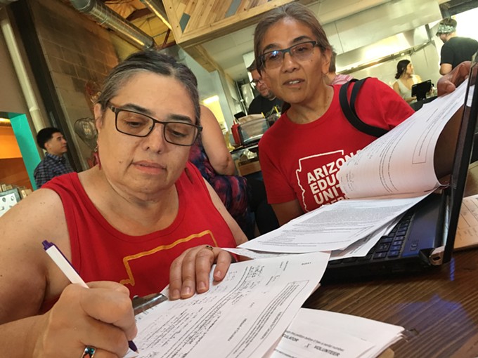 Tucson High School teachers Marea Janness (left) and Aida Castillo-Flores (right) sign up volunteers for petitioning sites at an INVESTinED gathering on June 6, 2018. - TORI TOM