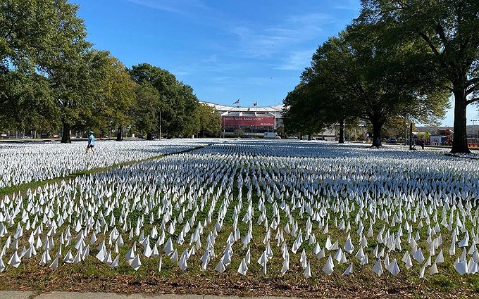 A shot of the more than 200,000 flags in the exhibit, "In America: How Could This Happen..." Visitors to the site are encouraged to walk among the flags, which stretch for two blocks, and mark them with names and tributes to loved ones who died of COVID-19. - MYTHILI GUBBI/CRONKITE NEWS