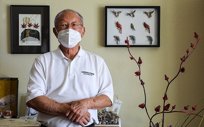 Dr. Richard Matsuishi was 4 when his family was displaced from its home in California in 1942 and brought to the Poston internment camp near Parker. Here he stands next to handcrafted birds made by his parents while imprisoned. - ALINA NELSON/CRONKITE NEWS