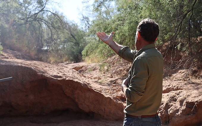 Ricardo Aguirre stands in a wash next to Interstate 10, which desertification and monsoon rains expanded in 2021. - PHOTO BY | BROCK BLASDELL/CRONKITE NEWS