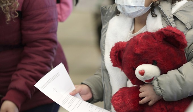 A young child clutching a stuffed animal is among a small group of asylum-seekers who have active applications under the Migrant Protection Protocols at the Paso del Norte Port of Entry in El Paso, Texas, on Feb. 26, 2021. - CBP PHOTO BY GLENN FAWCETT