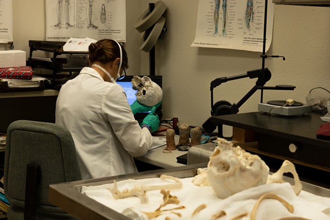 Examining unidentified remains is just one of the jobs for medical examiners, who have seen caseloads surge with a spike in the state’s death rate in recent years. In this 2021 photo, a doctor with the Pima County Medical Examiner’s Office examines a set of remains. - FILE PHOTO BY RAPHAEL ROMERO RUIZ/CRONKITE BORDERLANDS PROJECT