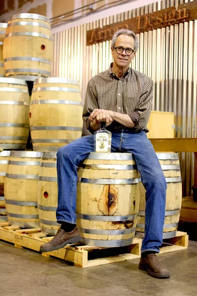 Stephen Paul proudly displays a bottle of his unaged, smoked whiskey. - HEATHER HOCH