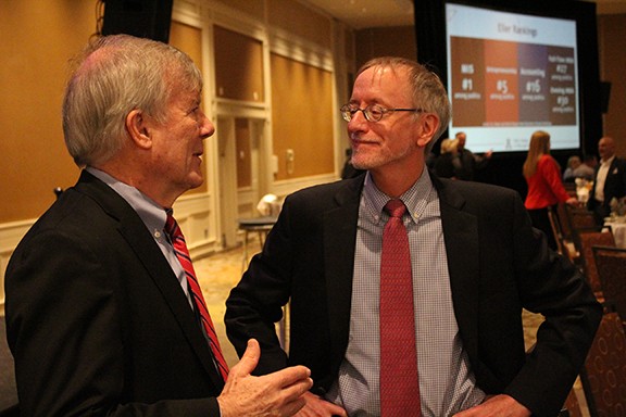 John Glassman, left, speaks to George Hammond, after they gave separate presentations about the state of the economy.